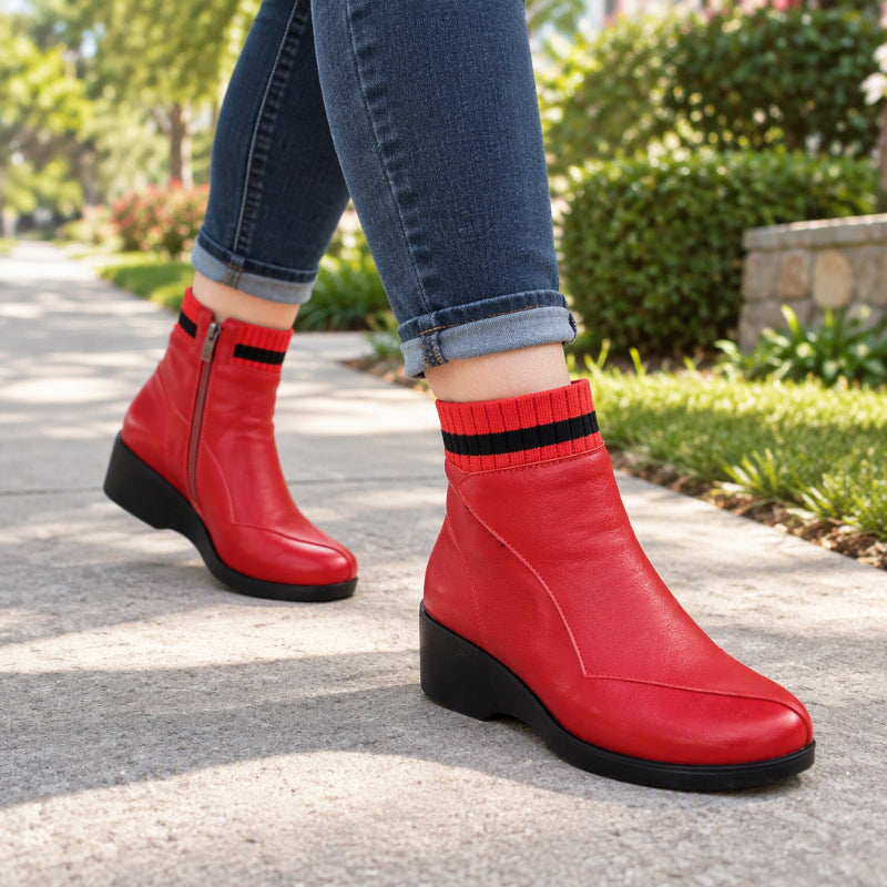 Red mid-calf boots styled with cuffed denim